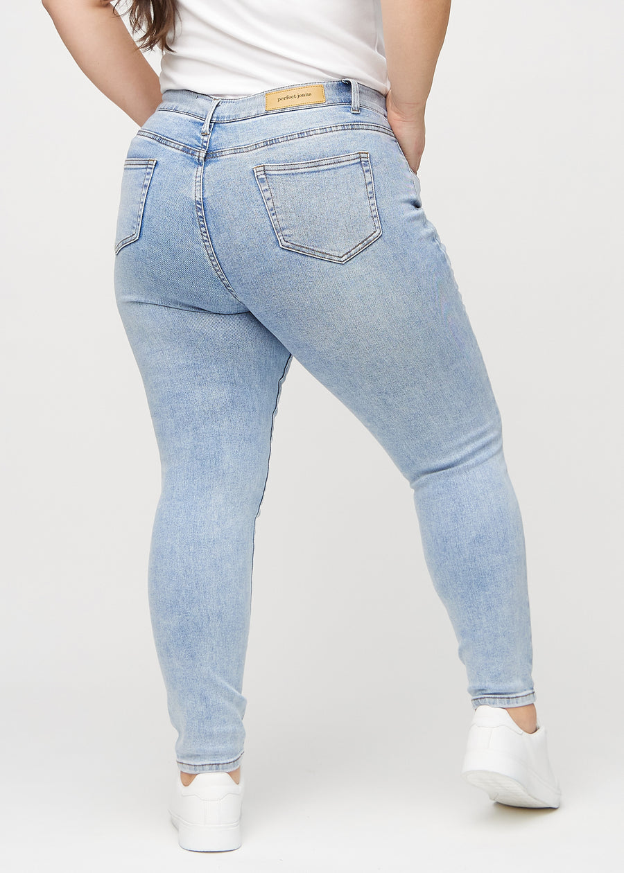Skinnyjeans för kvinnor i ljusblå, färgen Waves. Bakifrån på en plus size-modell, så att hela passformen syns.