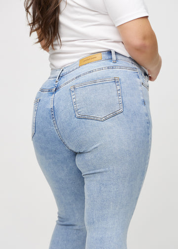 Skinnyjeans för kvinnor i ljusblå, färgen Waves. Närbild bakifrån på en plus size-modell som visar detaljerna.