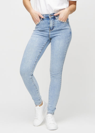 Skinnyjeans för kvinnor i ljusblå, färgen Waves. Framifrån på en modell, med nära passform runt benen.