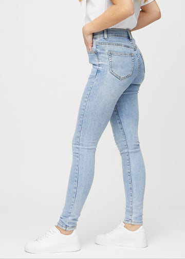 Skinnyjeans för kvinnor i ljusblå, färgen Waves. Från sidan på en modell.