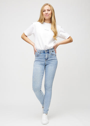 Skinnyjeans för kvinnor i ljusblå, färgen Waves. Helbild av en modell i jeansen.