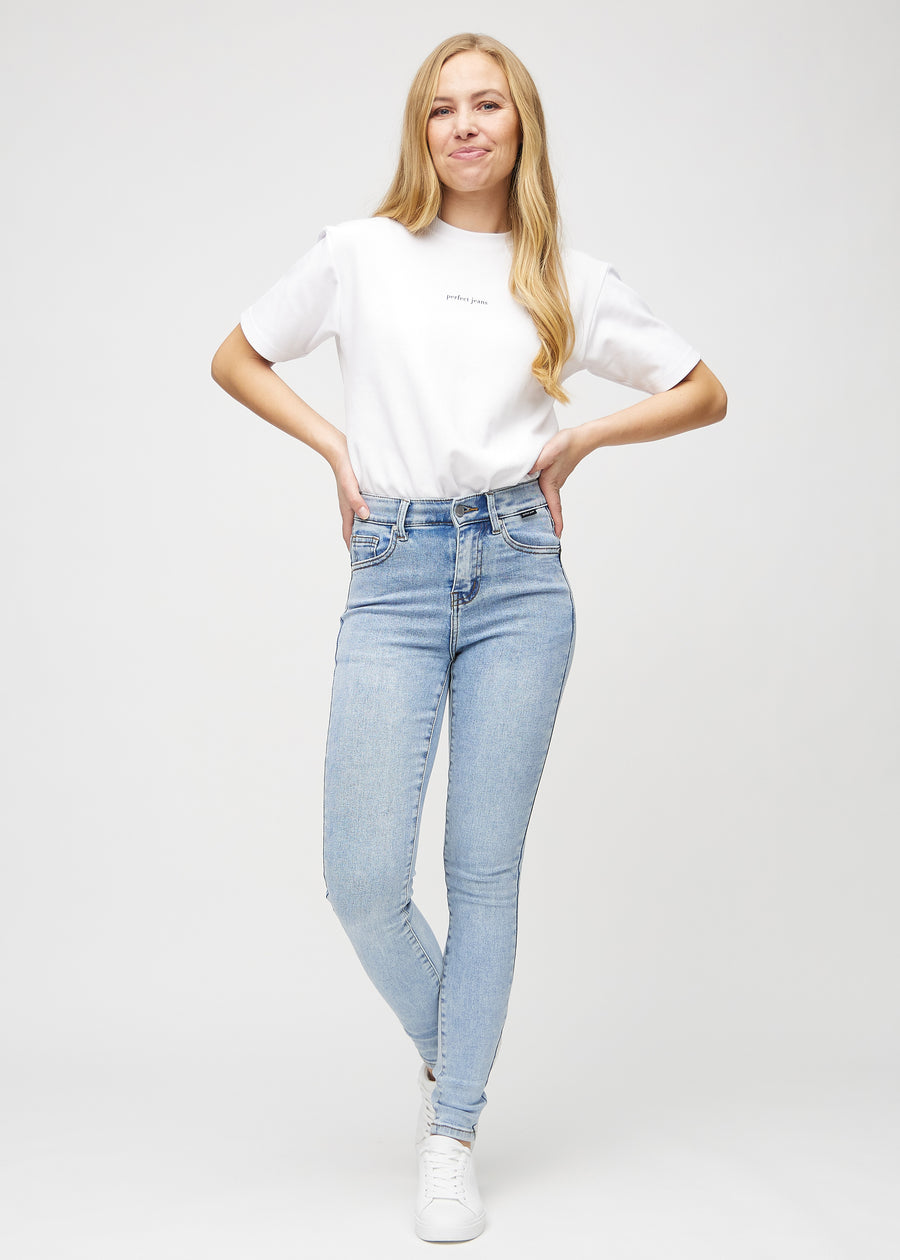 Skinnyjeans för kvinnor i ljusblå, färgen Waves. Helbild av en modell i jeansen.