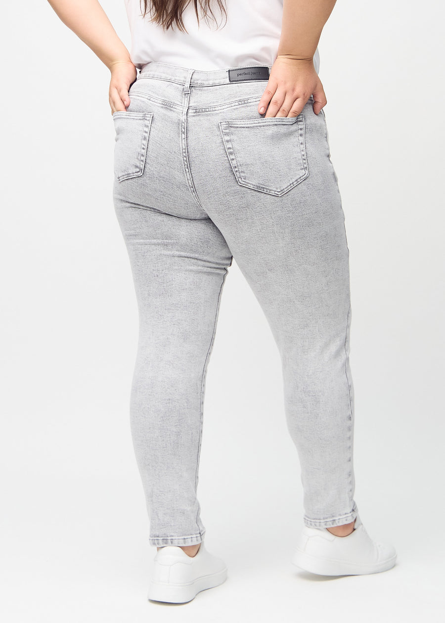 Slimjeans för kvinnor i ljusgrå, färgen Ashes. Bakifrån på en plus size-modell, så att hela passformen syns.