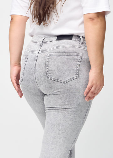 Slimjeans för kvinnor i ljusgrå, färgen Ashes. Närbild bakifrån på en plus size-modell som visar detaljerna.
