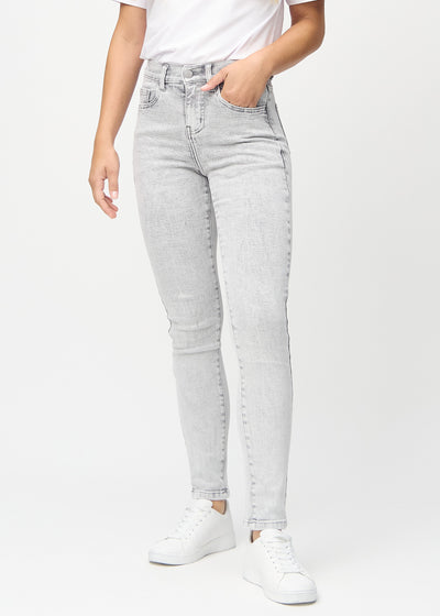Slimjeans för kvinnor i ljusgrå, färgen Ashes. Framifrån på en modell, med kroppsnära ben och lite mer utrymme vid anklarna.