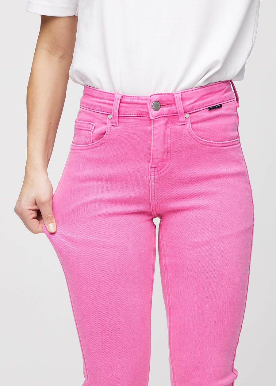 Slimjeans för kvinnor i ljusrosa, färgen Flamingos. En modell drar i jeanstyget vid låret för att visa stretchen.