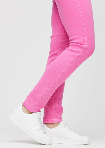 Slimjeans för kvinnor i ljusrosa, färgen Flamingos. Närbild vid anklarna på en modell som visar passformen vid bensluten.