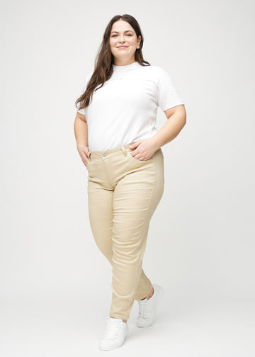 Slimjeans för kvinnor i beige, färgen Gazelles. Helbild av en plus size-modell som bär jeansen.