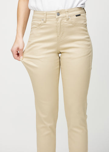 Slimjeans för kvinnor i beige, färgen Gazelles. En modell drar i jeanstyget vid låret för att visa stretchen.