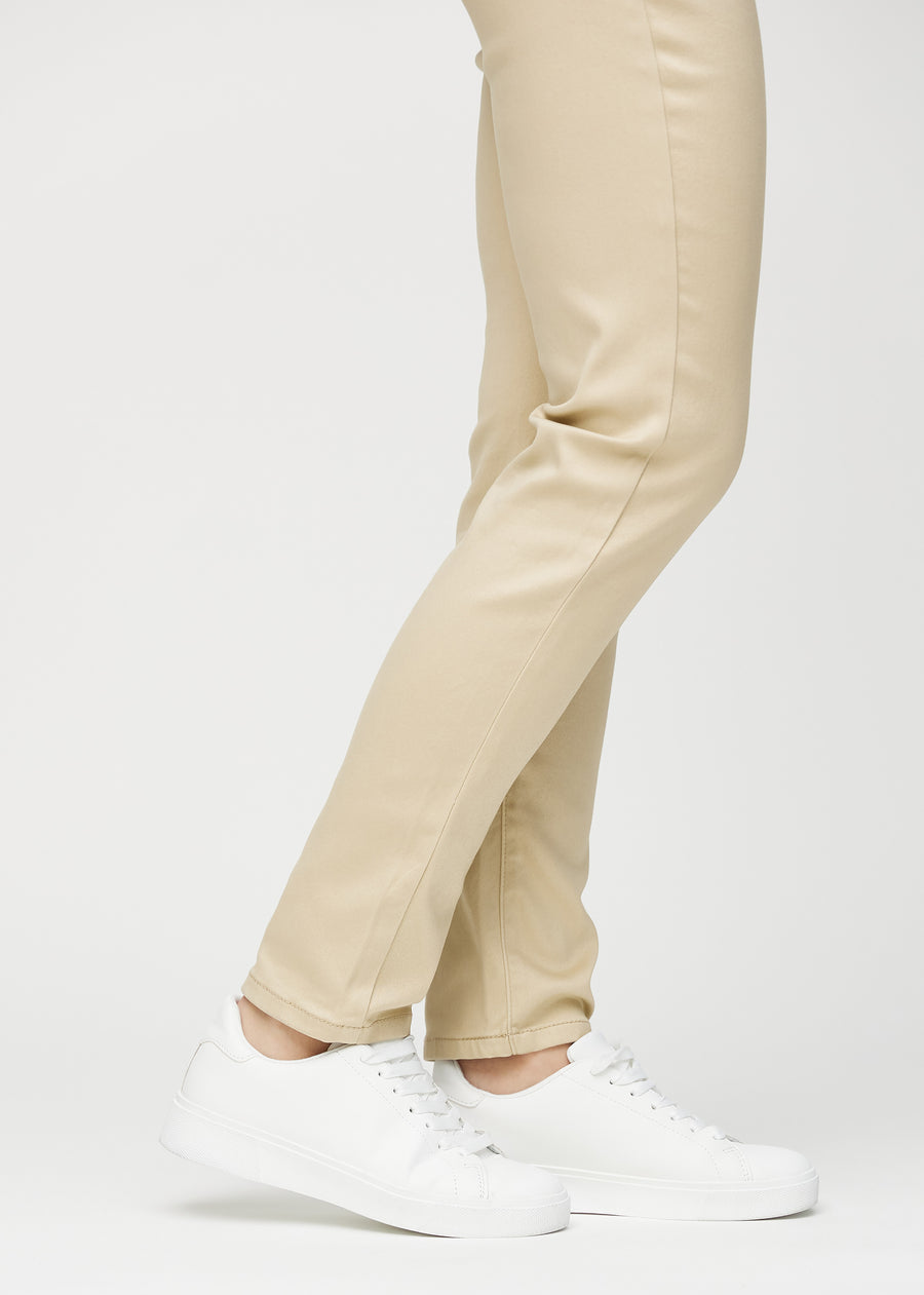 Slimjeans för kvinnor i beige, färgen Gazelles. Närbild vid anklarna på en modell som visar passformen vid bensluten.
