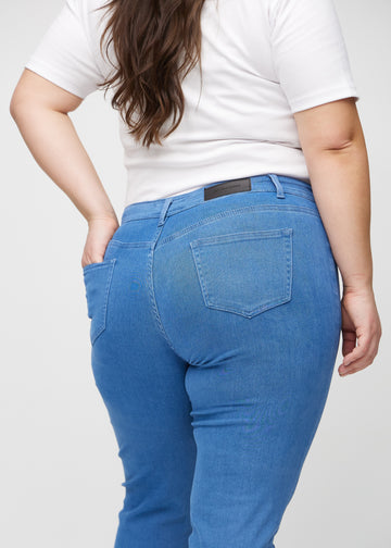 Slimjeans för kvinnor i blå, färgen Geraniums. Närbild bakifrån på en plus size-modell som visar detaljerna.