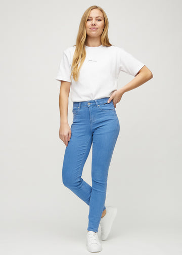 Slimjeans för kvinnor i blå, färgen Geraniums. Helbild av en modell som bär jeansen.