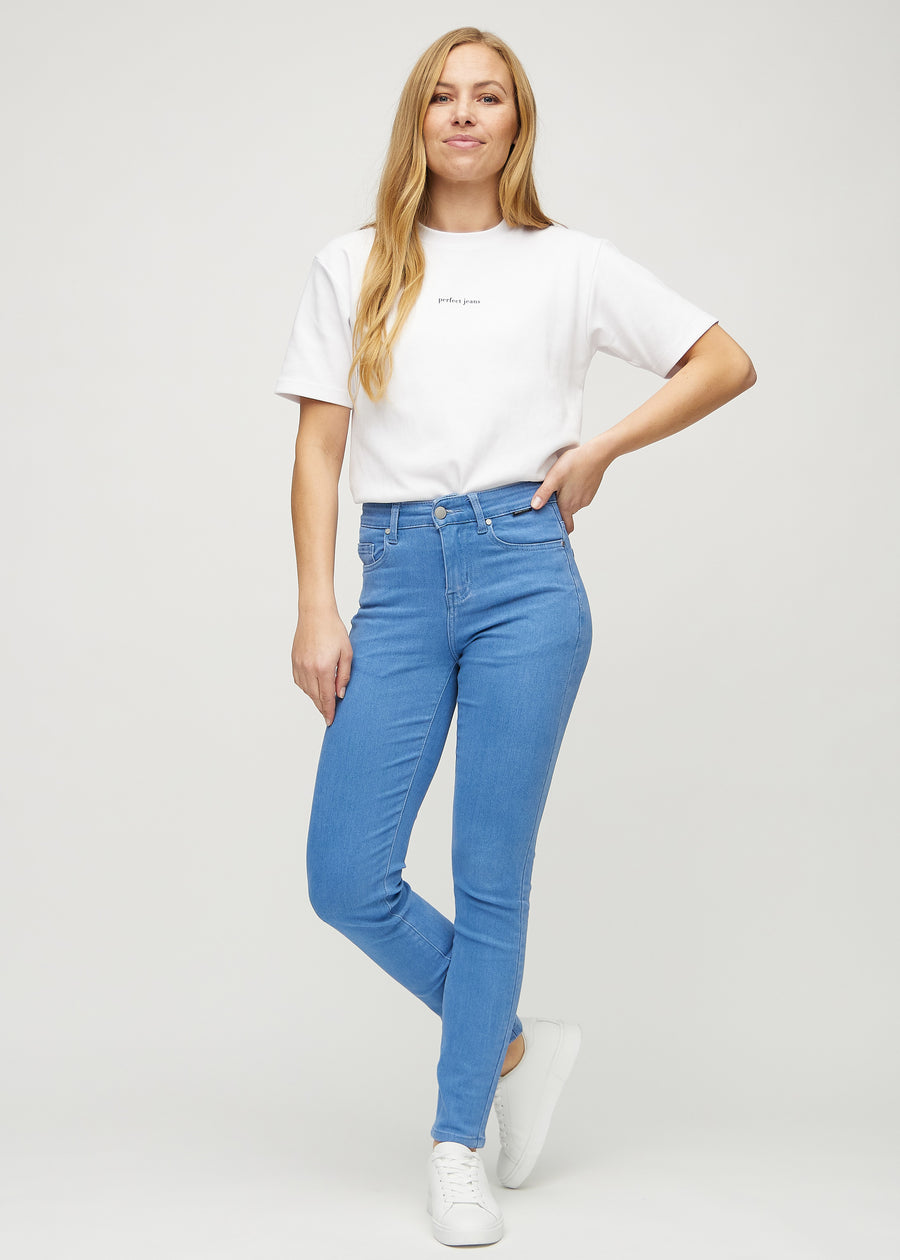 Slimjeans för kvinnor i blå, färgen Geraniums. Helbild av en modell som bär jeansen.