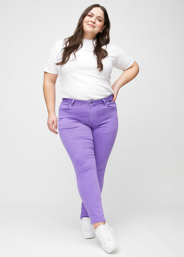 Slimjeans för kvinnor i lila, färgen Lavenders. Helbild av en plus size-modell som bär jeansen.
