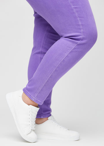 Slimjeans för kvinnor i lila, färgen Lavenders. Närbild vid anklarna på en plus size-modell som visar passformen vid bensluten.