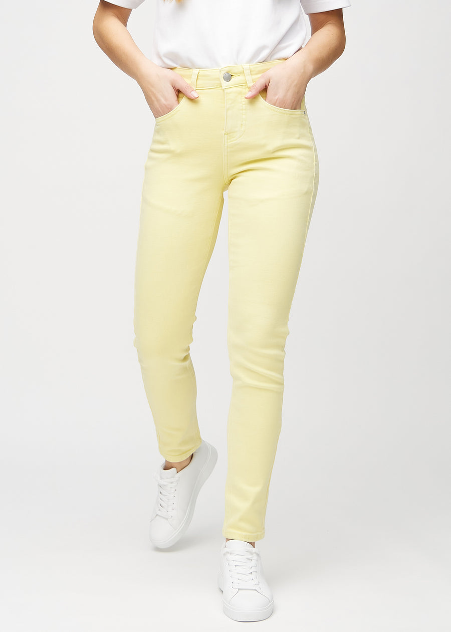 Slimjeans för kvinnor i ljusgul, färgen Lemonades. Framifrån på en modell, med kroppsnära ben och lite mer utrymme vid anklarna.