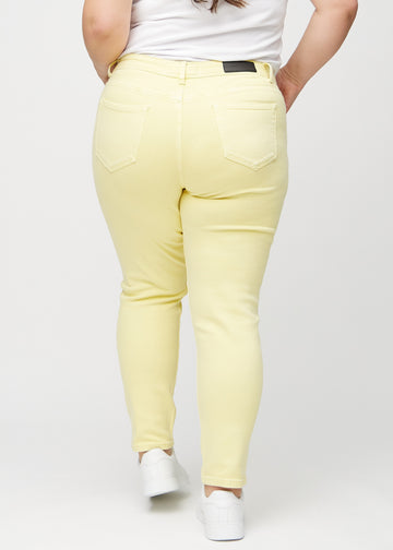 Slimjeans för kvinnor i ljusgul, färgen Lemonades. Bakifrån på en plus size-modell, så att hela passformen syns.