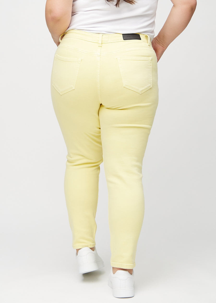 Slimjeans för kvinnor i ljusgul, färgen Lemonades. Bakifrån på en plus size-modell, så att hela passformen syns.
