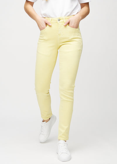Ljusgula slim jeans, modellnamn Lemonades, som sitter tätt längs benet, men något lösare vid ankeln, sedd framifrån.
