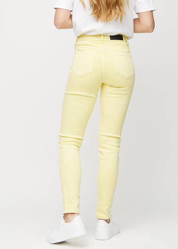 Slimjeans för kvinnor i ljusgul, färgen Lemonades. Bakifrån på en modell, så att hela passformen syns.