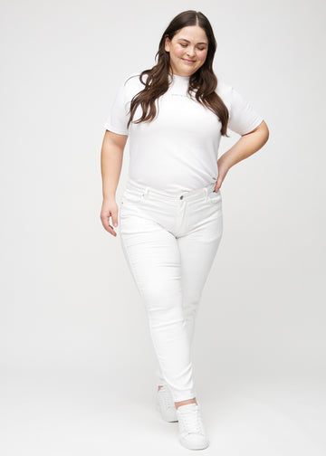 Slimjeans för kvinnor i vit, färgen Marguerites. Helbild av en plus size-modell som bär jeansen.