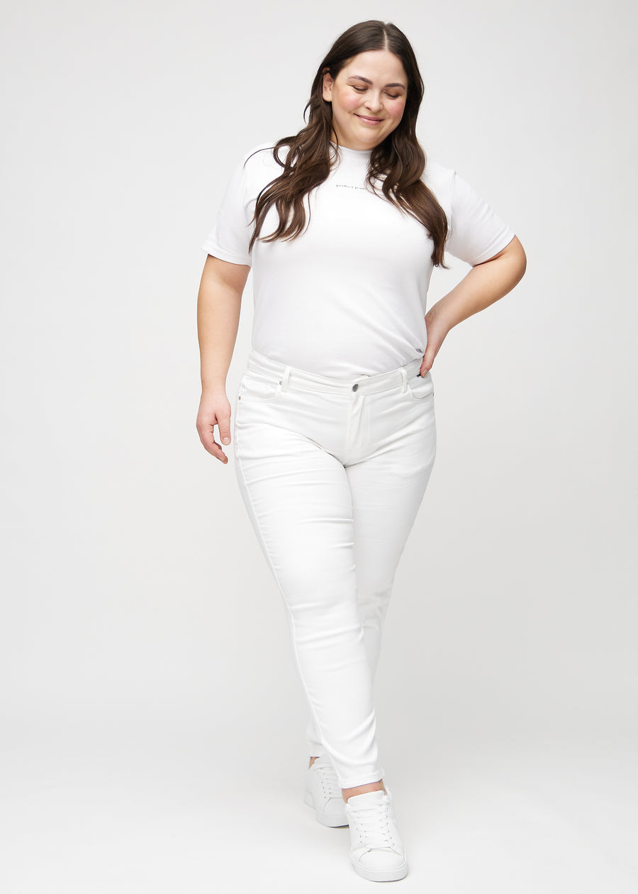 Slimjeans för kvinnor i vit, färgen Marguerites. Helbild av en plus size-modell som bär jeansen.
