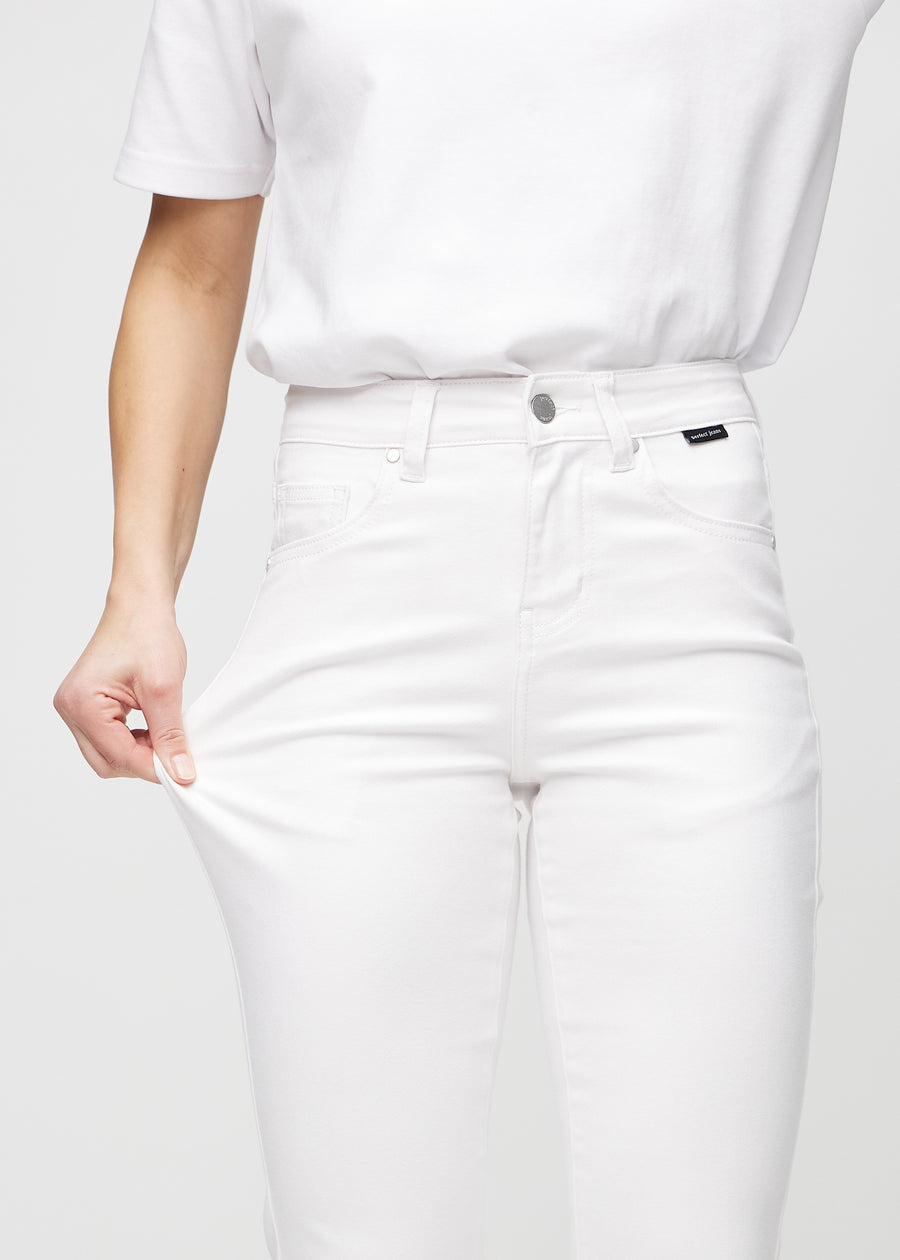 Slimjeans för kvinnor i vit, färgen Marguerites. En modell drar i jeanstyget vid låret för att visa stretchen.