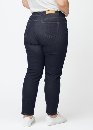 Djupt mörkblå denim jeans för kvinnor i färgen Midnights sedd bakifrån på plus-size-modell.