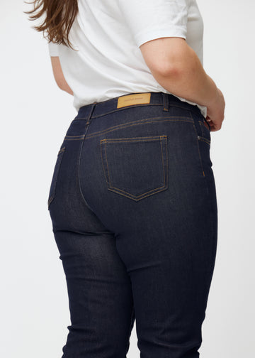 Djupt mörkblå denim jeans för kvinnor i färgen Midnights sedd bakifrån i närbild på plus-size-modell.