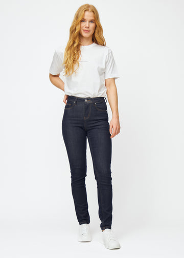 Helbild av modell i djupt mörkblå denim jeans för kvinnor i färgen Midnights med slim passform.
