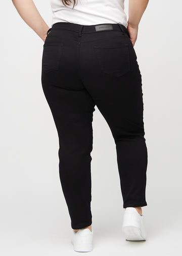 Slimjeans för kvinnor i svart, färgen Ravens. Bakifrån på en plus size-modell, så att hela passformen syns.