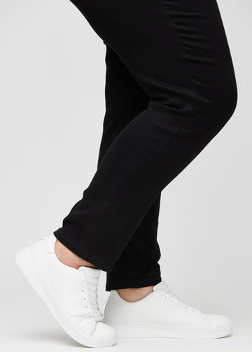 Anklarna på en plus size-modell, så att man kan se hur tätt jeansen sitter i en Slim passform.