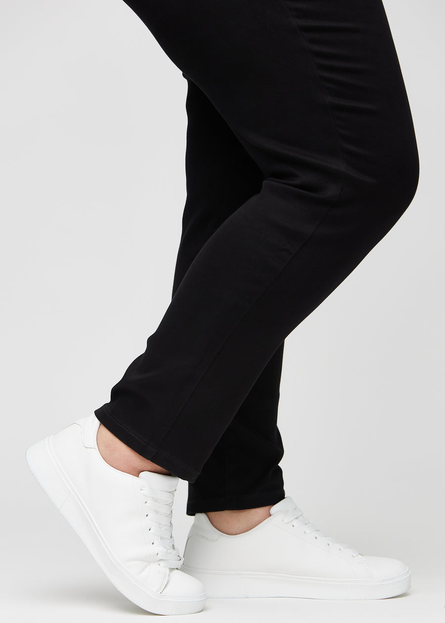 Anklarna på en plus size-modell, så att man kan se hur tätt jeansen sitter i en Slim passform.
