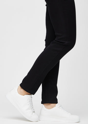 En modells anklar, så att man kan se hur tätt jeansen sitter i en Slim passform.