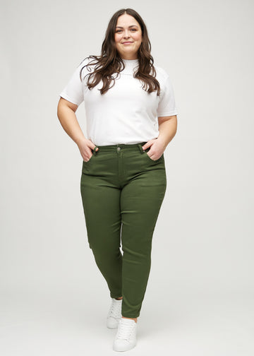 Slimjeans för kvinnor i mörkgrön, färgen Renewals. Helbild av en plus size-modell som bär jeansen.