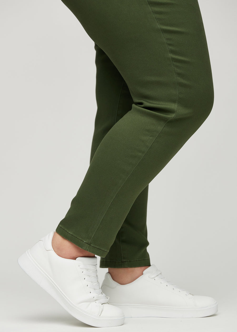 Slimjeans för kvinnor i mörkgrön, färgen Renewals. Närbild vid anklarna på en plus size-modell som visar passformen vid bensluten.