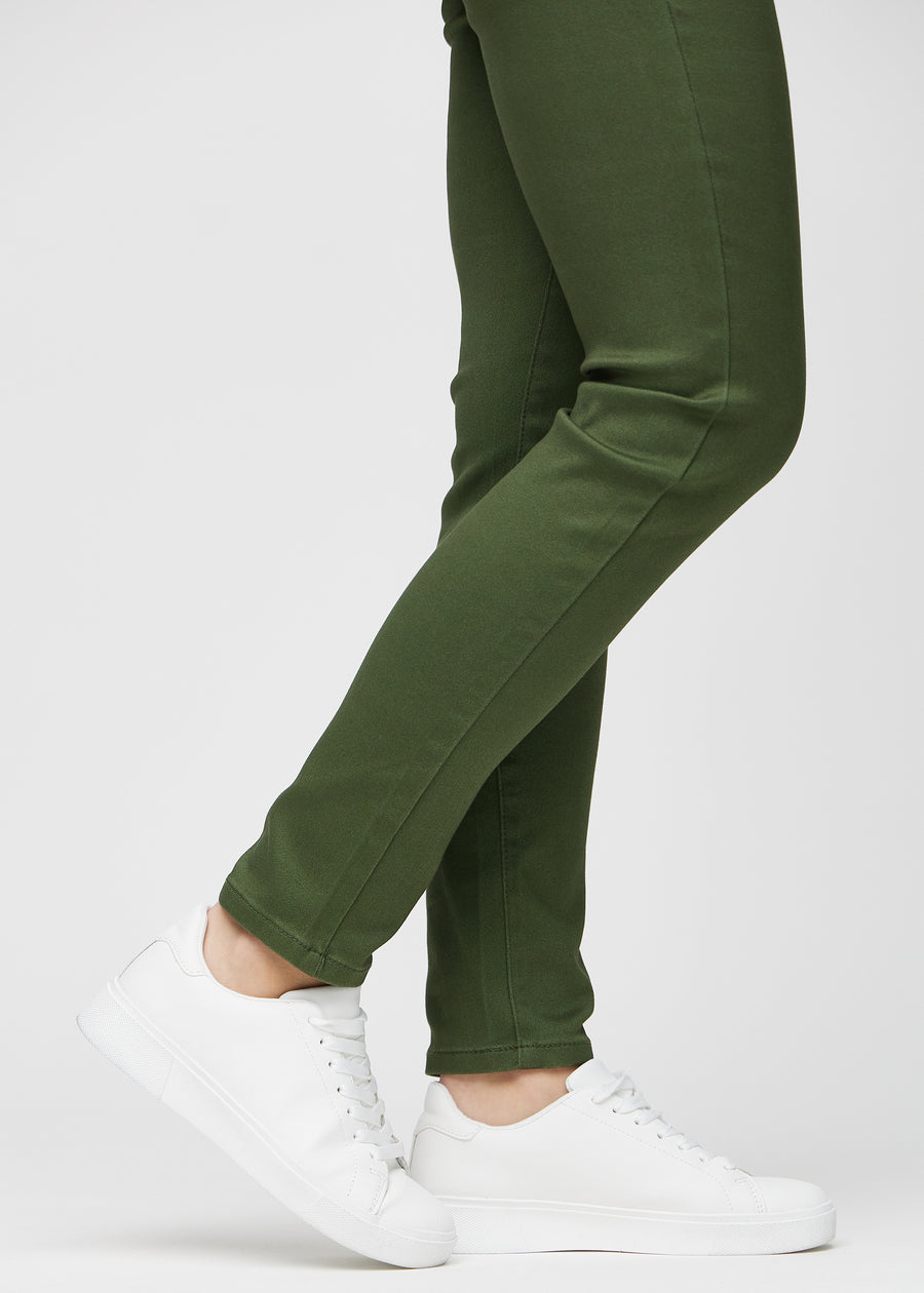 Slimjeans för kvinnor i mörkgrön, färgen Renewals. Närbild vid anklarna på en modell som visar passformen vid bensluten.