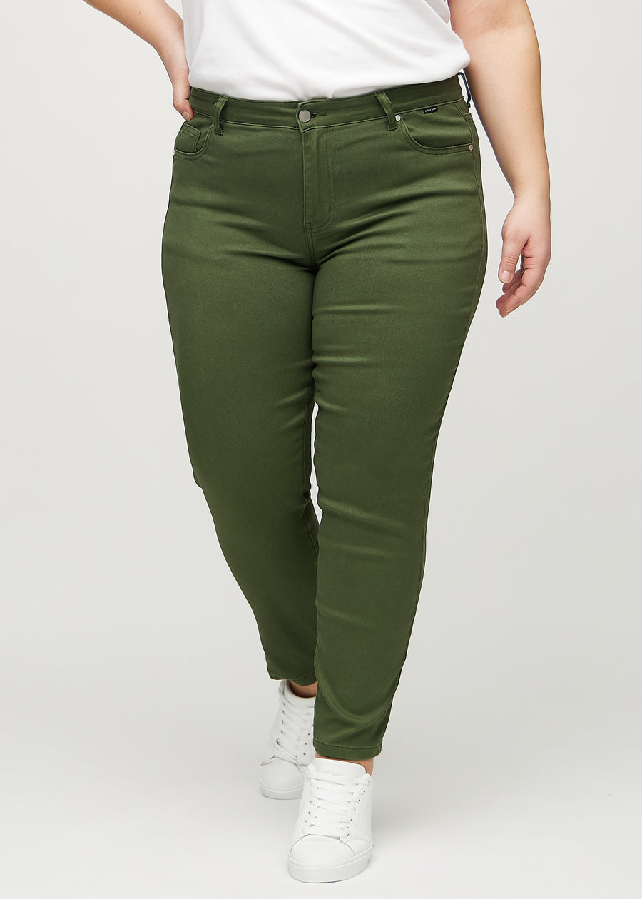 Slimjeans för kvinnor i mörkgrön, färgen Renewals. Framifrån på en plus size-modell, med kroppsnära ben och lite mer utrymme vid anklarna.
