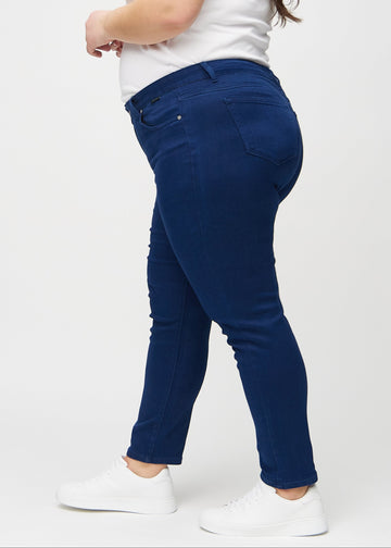 Slimjeans för kvinnor i mörkblå, färgen Royals. Från sidan på en plus size-modell.