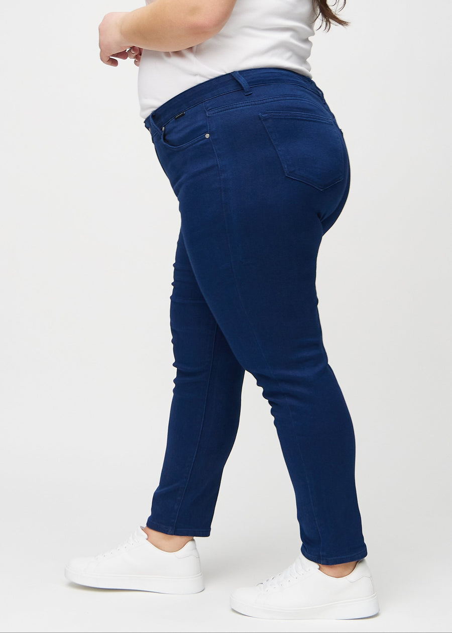 Slimjeans för kvinnor i mörkblå, färgen Royals. Från sidan på en plus size-modell.