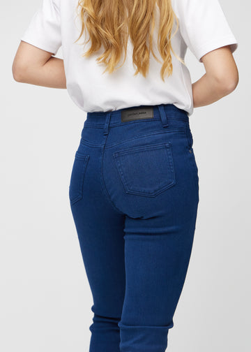 Slimjeans för kvinnor i mörkblå, färgen Royals. Närbild bakifrån på en modell som visar detaljerna.