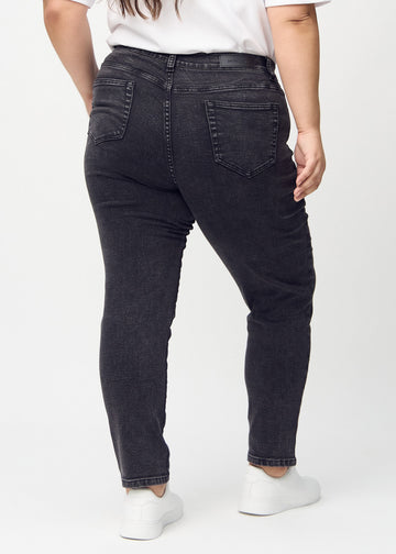 Slimjeans för kvinnor i mörkgrå, färgen Shadows. Bakifrån på en plus size-modell, så att hela passformen syns.