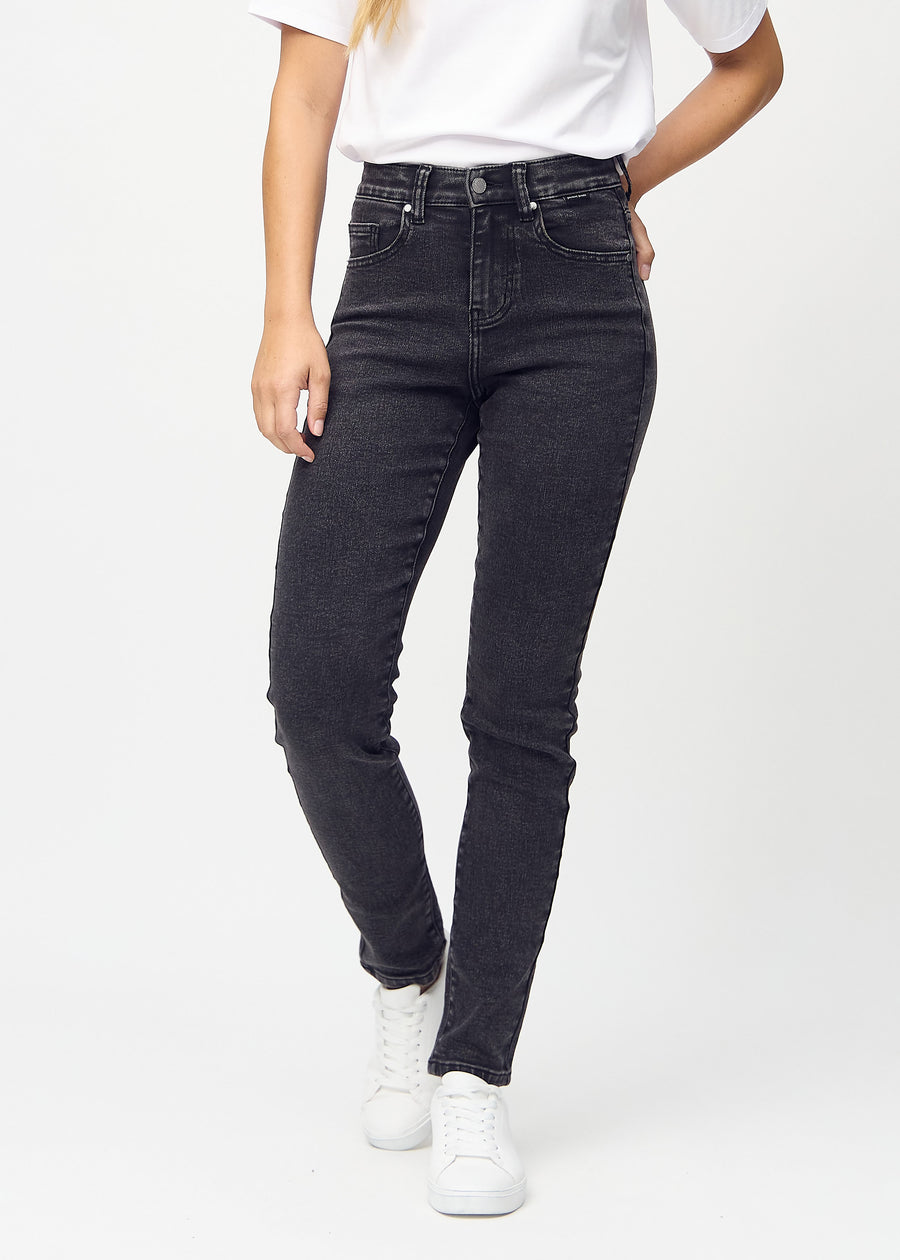 Slimjeans för kvinnor i mörkgrå, färgen Shadows. Framifrån på en modell, med kroppsnära ben och lite mer utrymme vid anklarna.