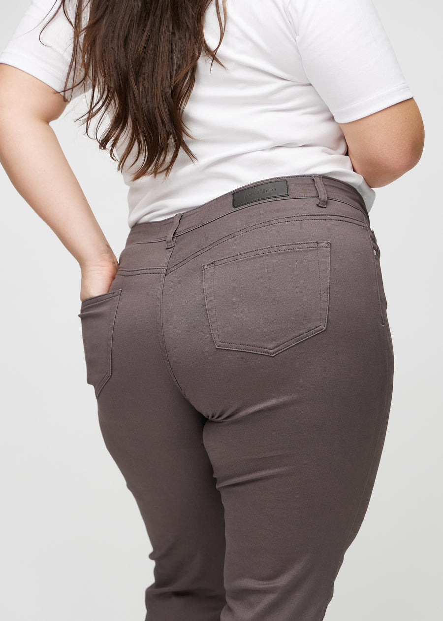 Slimjeans för kvinnor i gråbrun, färgen Thunders. Närbild bakifrån på en plus size-modell som visar detaljerna.