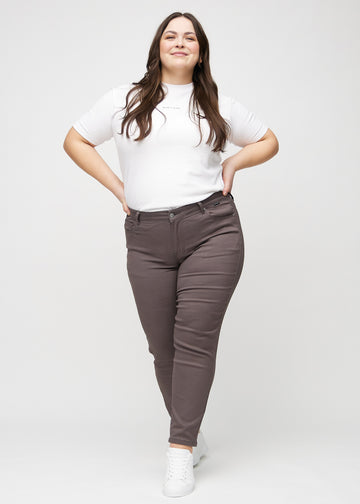 Slimjeans för kvinnor i gråbrun, färgen Thunders. Helbild av en plus size-modell som bär jeansen.