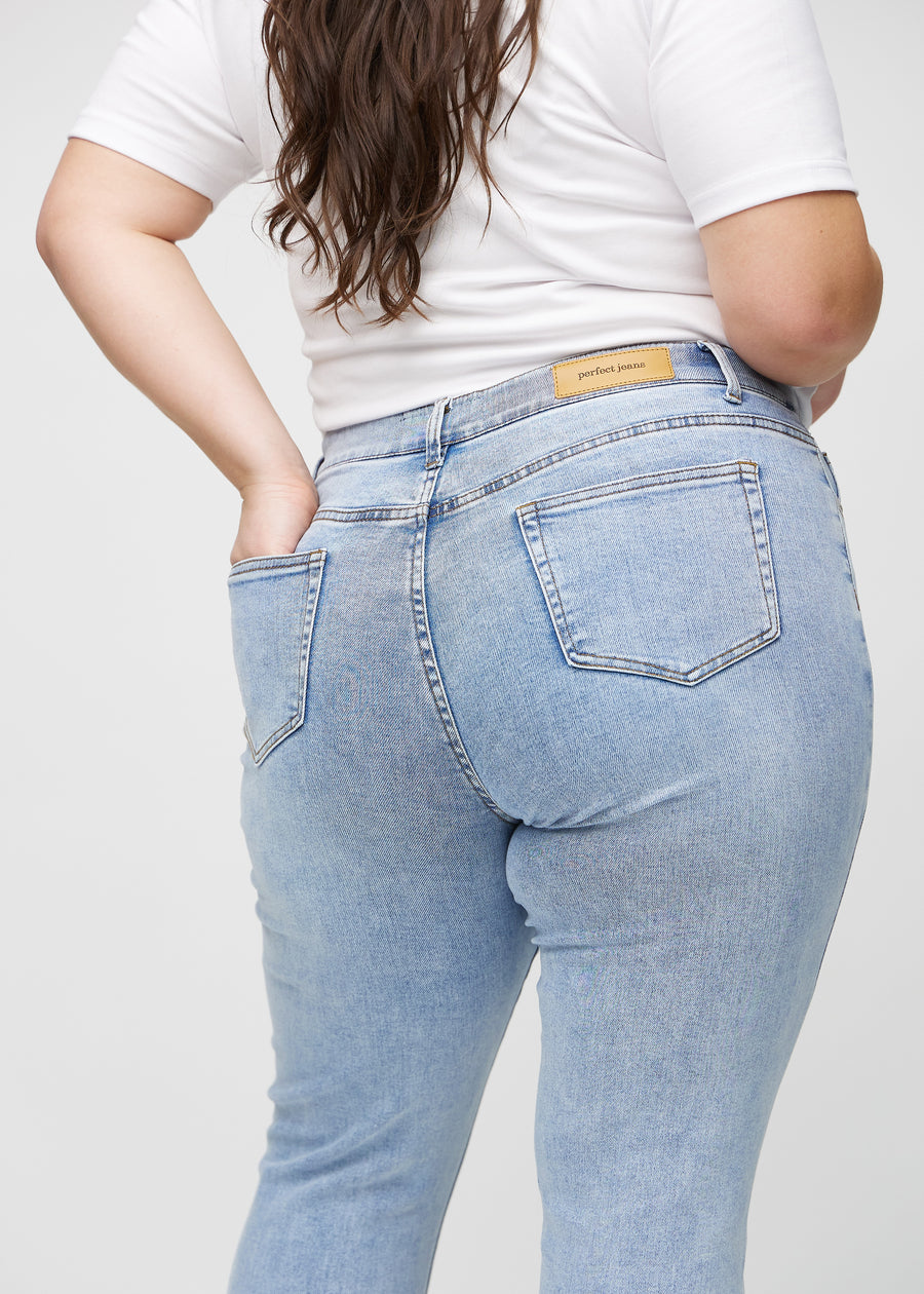 Slimjeans för kvinnor i ljusblå, färgen Waves. Närbild bakifrån på en plus size-modell som visar detaljerna.