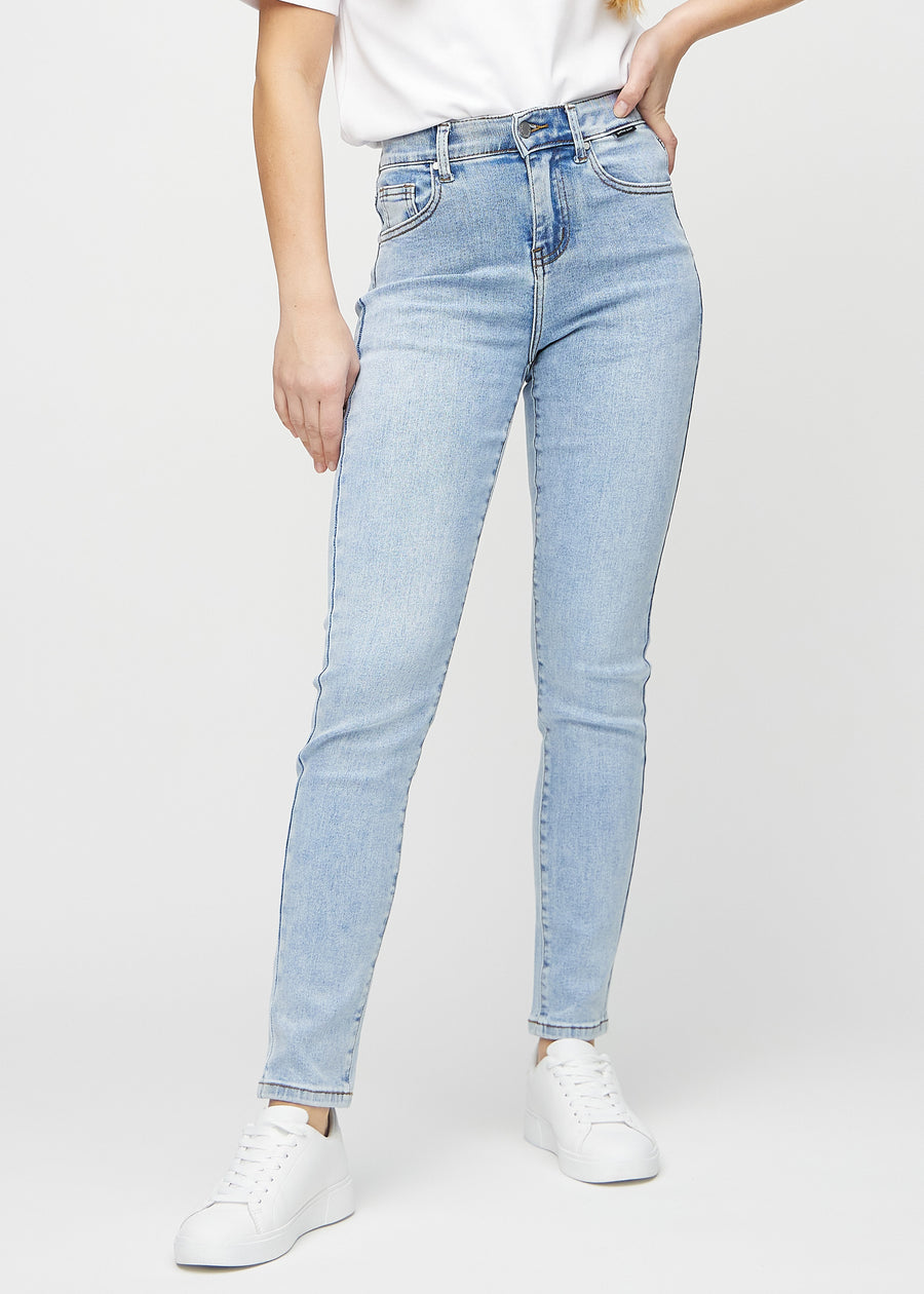 Slimjeans för kvinnor i ljusblå, färgen Waves. Framifrån på en modell, med kroppsnära ben och lite mer utrymme vid anklarna.