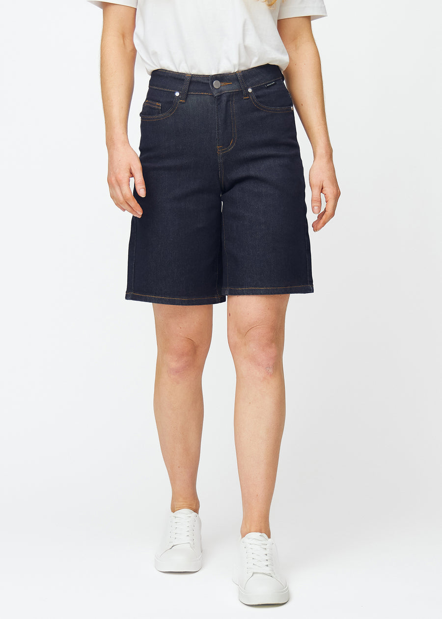 Mörkblå denimshorts för dam i färgen Midnights med loose passform som sitter vid höften och faller löst över låren, sett framifrån.