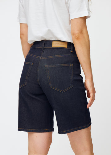 Mörkblå denimshorts för dam i färgen Midnights sett bakifrån i närbild för att visa passform och detaljer.