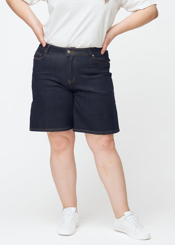 Mörkblå denimshorts för dam i färgen Midnights med loose passform sett framifrån på plus-size modell.